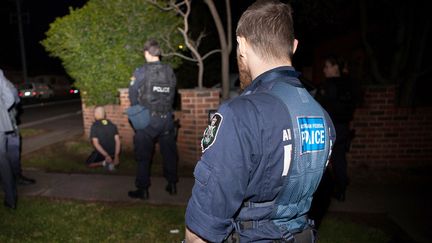 Des policiers encadrent un homme arr&ecirc;t&eacute; le 18 septembre 2014 &agrave; Sydney (Australie) dans le cadre d'une vaste op&eacute;ration antiterroriste. (AUSTRALIAN FEDERAL POLICE / AFP)