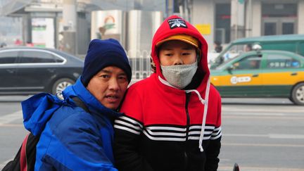 Un enfant porte un masque en raison de la pollution de l'air, à Pékin (Chine), le 28 novembre 2015.&nbsp; (MAHMUT ATANUR / ANADOLU AGENCY / AFP)