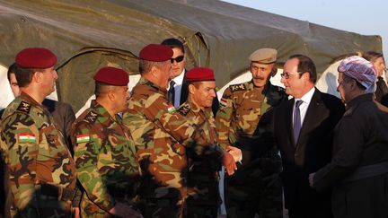 François Hollande salue des soldats kurdes peshmergas dans une base située au nord de Mossoul (Irak), lundi 2 janvier 2017, en compagnie du président de la région autonome Massoud Barzani (à droite). (CHRISTOPHE ENA / POOL / AFP)