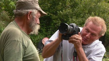 Le photographe Claude Fougeirol en pleine séance photo avec un agriculteur ardéchois.&nbsp; (FRANCEINFO)