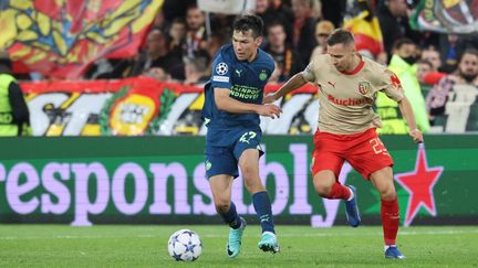 Le Mexicain Hirving Lozano au duel avec le Lensois Przemyslaw Frankowski, lors de Lens-PSV, le 24 octobre 2023. (FRANCOIS LO PRESTI / AFP)