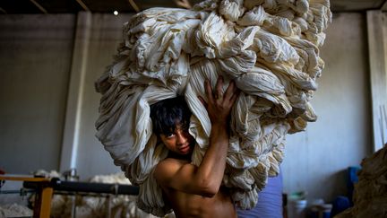 Un ouvrier&nbsp;travaille dans une usine de vêtements, le 8 septembre 2015, à Dacca (Bangladesh).&nbsp; (MOHAMMAD PONIR HOSSAIN / NURPHOTO / AFP)