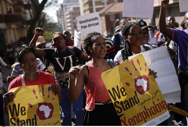 Des Sud-Africains manifestent contre des attaques xénophobes à Johannesburg le 23 avril 2015. Sur l'affiche tenue par la jeune femme au centre, on peut lire : "Nous nous opposons à la xénophobie." (JEROME DELAY/AP/SIPA / AP)