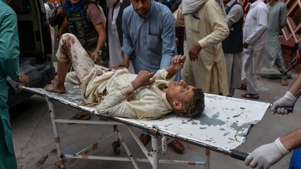 Un blessé&nbsp;sur&nbsp;un brancard après l'attentat qui a fait au moins 62 mort&nbsp;dans le district de Haska Mina (est de l'Afghanistan), le 18 octobre 2019.&nbsp; (NOORULLAH SHIRZADA / AFP)