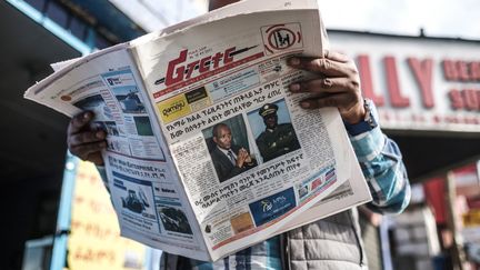 Un&nbsp;Ethiopien lit,&nbsp;le 24 juin 2019, le journal "The Reporter", qui dresse les portraits de&nbsp;Ambachew Mekonnen et du général Seare Mekonnen&nbsp;assassinés deux jours auparavant.&nbsp; (EDUARDO SOTERAS / AFP)