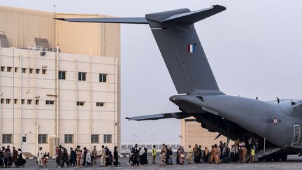 Des personnes évacuées de Kaboul débarquent à la base militaire française de Al Dhafra, à Abou Dhabi (Emirats Arabes Unis), le 23 août 2021. (BERTRAND GUAY / AFP)