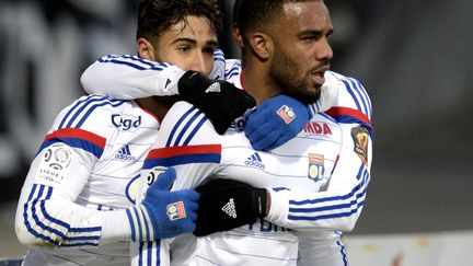 Les attaquants lyonnais Nabil F&eacute;kir et Alexandre Lacazette se congratulent apr&egrave;s la victoire de leur &eacute;quipe &agrave; domicile contre Nantes, le 22 f&eacute;vrier 2015.&nbsp; (JEAN-PHILIPPE KSIAZEK / AFP)