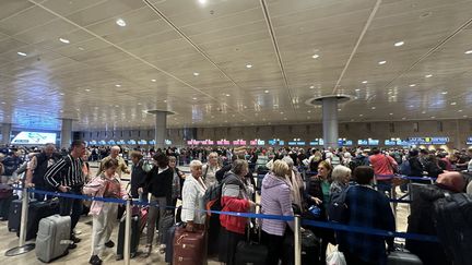 Des passagers à l'aéroport Ben-Gourion de Tel Aviv (Israël), le 8 octobre 2023, au lendemain de l'attaque du Hamas dans le pays. (TURGUT ALP BOYRAZ / ANADOLU AGENCY / AFP)