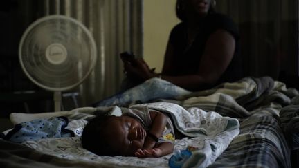 Un bébé dort dans une église de Freeport, sur l'île de Grand Bahama,&nbsp;aménagée comme un abris juste avant l'arrivée de l'ouragan Dorian, le 1er septembre 2019.&nbsp; (RAMON ESPINOSA / AP / SIPA)