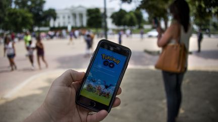 Un homme joue à "Pokémon Go" à Washington, aux Etats-Unis, le 12 juillet 2016. (JIM WATSON / AFP)