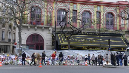 Des passants rendent hommage aux victimes de l'attentat au Bataclan, à Paris, le 29 novembre 2015. (MIGUEL MEDINA / AFP)