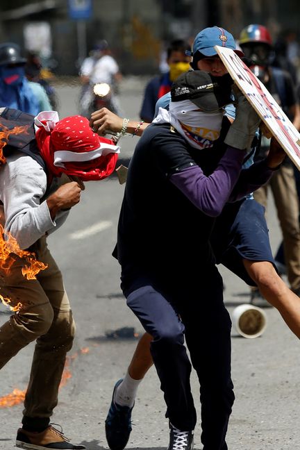 Un homme prend feu en tentant de lancer un cocktail Molotov,&nbsp;à Caracas, le 10 juillet 2017 (ANDRES MARTINEZ CASARES / REUTERS)