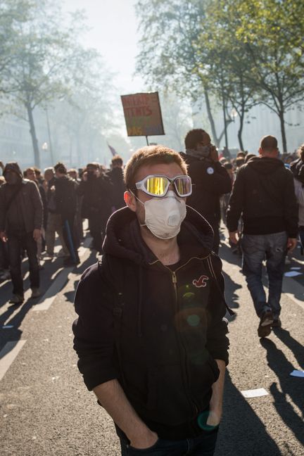 Les manifestants avancent masqués pour se protéger contre les gaz lacrymogènes, le 1er&nbsp;mai, à Paris. (BENJAMIN GIRETTE / IP3 / MAXPPP)