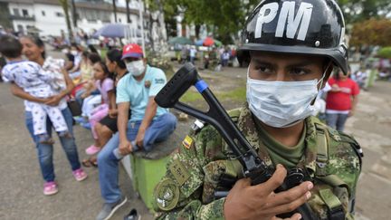 Un soldat colombien portant un masque lors d'une patrouille pendant une campagne de vaccination, après les glissements de terrain, à Mocoa, le 6 avril 2017. (LUIS ROBAYO / AFP)