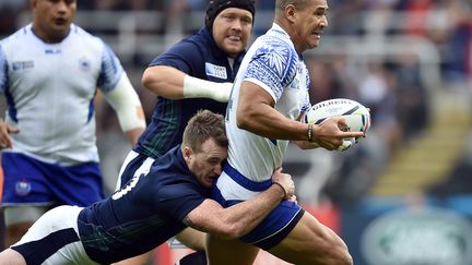 L'ailier samoan Paul Perez tente d'échapper à Stuart Hogg (BERTRAND LANGLOIS / AFP)