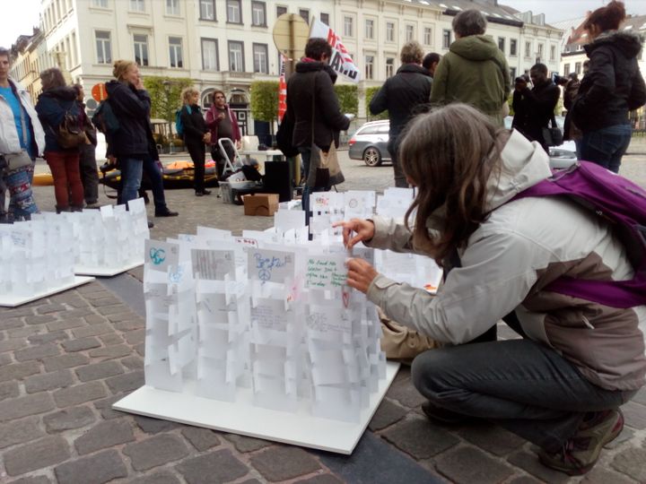 Le 16 avril à Bruxelles, l'un des membres de Human's welcome rassemble les cartes&nbsp;rédigées par des migrants et des Européens rencontrés lors de la course Lesbos-Bruxelles. (LAXMI LOTA / RADIO FRANCE)