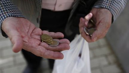 Angel Gomez Gamallo, 79 ans, compte ses pièces pour pouvoir se payer un journal. 
 (Reuters - Susana Vera)