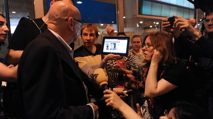 Des journalistes montrant &agrave; un passager une photo d'Edward Snowden &agrave; l'a&eacute;roport de Moscou, le 23 juin 2013. (VASILY MAXIMOV / AFP)