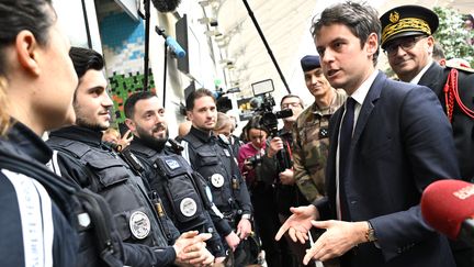 Le Premier ministre, Gabriel Attal, s'entretient avec le personnel de sécurité de la SNCF lors d'une visite à la gare Saint-Lazare à Paris, le 25 mars 2024. (BERTRAND GUAY / AFP)