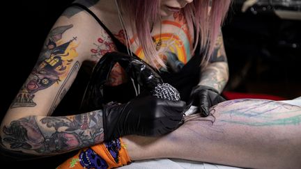 Un client en pleine séance de tatouage, au Mondial à Paris, le 15 février 2019. (THOMAS SAMSON / AFP)