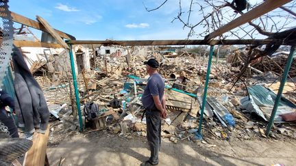 Victor devant un tas de ruines, après les bombardements russes sur le village ukrainien de Velyka Pysarivka. (AGATHE MAHUET / RADIO FRANCE)