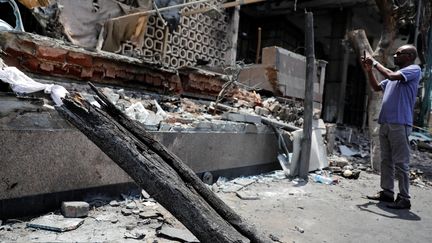 Un homme prend en photo la façade de l'Institut national du cancer après une explosion, au Caire, le 5 août 2019. (AMR ABDALLAH DALSH / REUTERS)