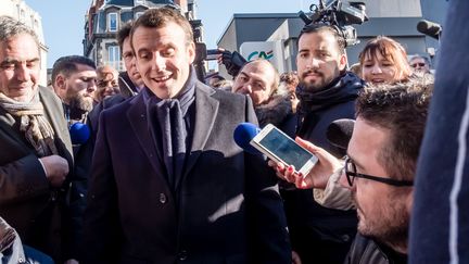 Emmanuel Macron, leader du mouvement En Marche, en déplacement sur un marché de Clermont-Ferrand (Puy-de-Dôme),&nbsp;dans le cadre de la campagne présidentielle, le 9 janvier 2017. Derrière lui, Alexandre Benalla, l'un de ses agents de sécurité, maintient la foule à distance.&nbsp; (KONRAD K./SIPA)