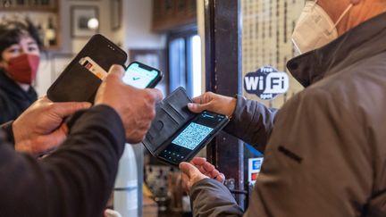 Un restaurateur vérifie le pass sanitaire d'un client. (CRISTIANO MINICHIELLO / AVALON / MAXPPP)