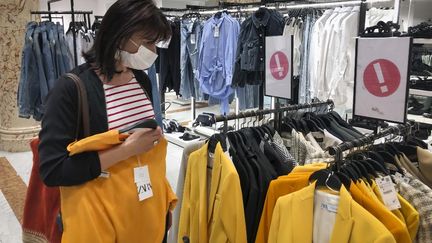 Une femme porte un masque de protection dans un magasin de prêt-à-porter, à Nice (Alpes-Maritimes), le 19 mai 2020. (ARIE BOTBOL / HANS LUCAS / AFP)