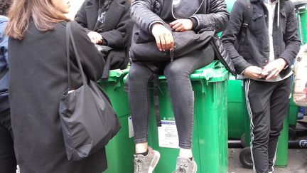 Les élèves du lycée Voltaire (Paris), assis sur les poubelles pour empêcher la direction de dégager l'entrée (SOLENNE LE HEN / RADIO FRANCE)