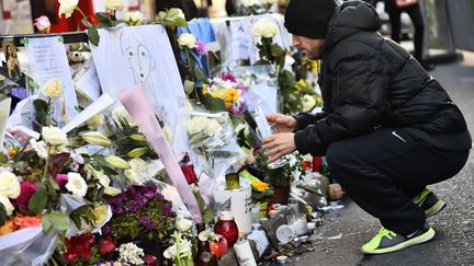 Un homme se recueille en hommage aux victimes des attentats de Paris, devant le restaurant "La Belle Equipe", le 22 novembre 2015 à Paris. (LOIC VENANCE / AFP)