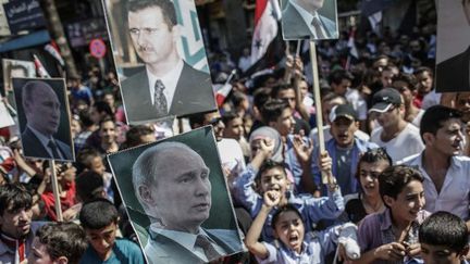 Les effigies des présidents russe, Vladimir Poutine, et syrien, Bachar al-Assad, côte à côte lors d'une manifestation de soutien à Lattaquié, en pays alaouite, le 24 septembre 2013. (Andrey Stenin/Ria Novosti)