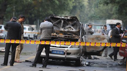 La police indienne s'affaire autour de la voiture qui a explos&eacute;, le 13 f&eacute;vrier 2012, pr&egrave;s de l'ambassade isra&eacute;lienne &agrave; New Delhi (Inde). (SAJJAD HUSSAIN / AFP)