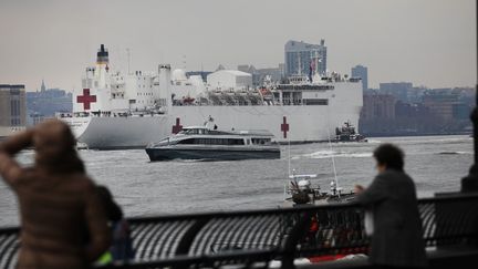 Des habitants&nbsp;saluent l'arrivée d'un navire-hôpital à New York (Etats-Unis), le 30 mars 2020. (SPENCER PLATT / GETTY IMAGES NORTH AMERICA)