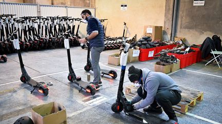 Des employés travaillent sur des trottinettes électriques à Marseille, le 18 novembre 2019. (GERARD JULIEN / AFP)