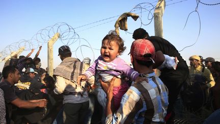 Des familles syriennes tentent de passer la fronti&egrave;re avec la Turquie pour fuir leur pays,&nbsp;le 14 juin 2015&nbsp;&agrave; Akcakale (Turquie).&nbsp; (LEFTERIS PITARAKIS / AP / SIPA)