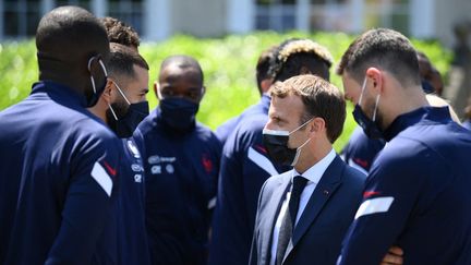 L'échange entre Emmanuel Macron et Karim Benzema lors de la visite du président de la République à Clairefontaine, jeudi 10 juin 2021. (FRANCK FIFE / AFP)