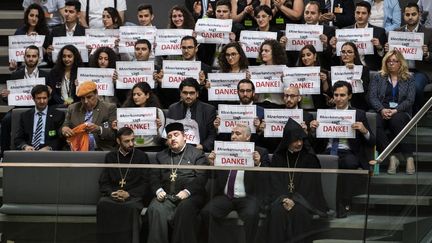 Des Arméniens tiennent des pancartes de remerciement dans le parlement allemand après le vote de reconnaissance du génocide arménien à Berlin (Allemagne), le 2 juin 2016. (ODD ANDERSEN / AFP)