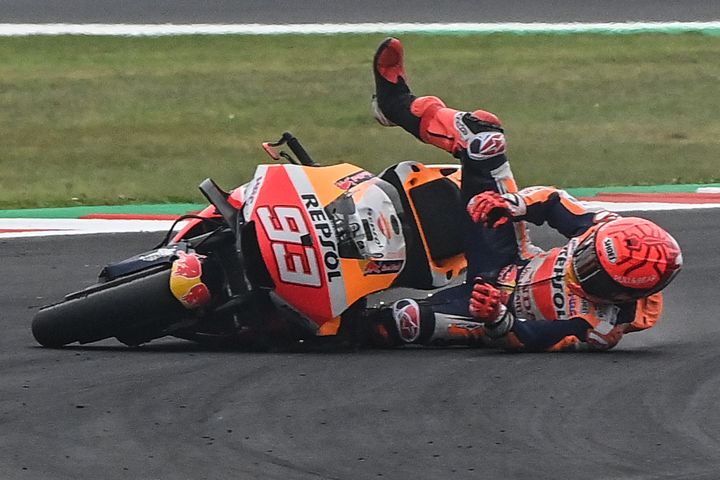 Marc Marquez chute lors du Grand Prix d'Emilie-Romagne, le 23 octobre 2021. (ANDREAS SOLARO / AFP)