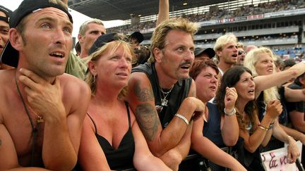 Des fans de Johnny Hallyday attendent le début du concert, le 25 juin 2003, au stade Vélodrome de Marseille (Bouches-du-Rhône).&nbsp; (GERARD JULIEN / AFP)