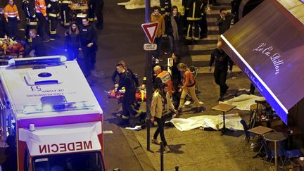 Un blessé est évacué près du bar Le Carillon et du restaurant Le Petit Cambodge, où des cadavres ont été couverts par des bâches, dans le 10e arrondissement de Paris, le 13 novembre 2015. (CHRISTIAN HARTMANN / REUTERS)