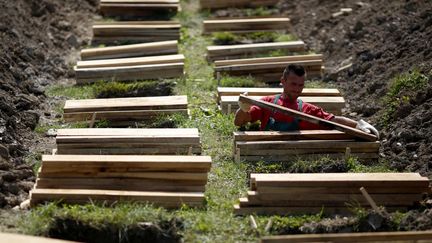 Un employ&eacute; pr&eacute;pare des tombes au futur m&eacute;morial des victimes du massacre de Srebrenica &agrave; Potocari (Bosnie-Herz&eacute;govine), le 7 juillet 2014. (DADO RUVIC / REUTERS)