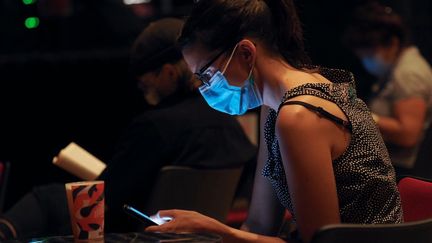 Une femme utilise un smartphone lors d'un festival de musique. (GUILLAUME SOUVANT / AFP)