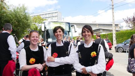 C'est Katell, au milieu, qui dit cela en s'amusant. Elle joue de la bombarde, "la guitare c'est tellement plus simple". Les trois femmes ont besoin de décompresser après une représentation en plein soleil au stade du Moustoir.  Elles ne le savent pas encore, mais la victoire au championnat attend leur bagad : Cap Caval.
Katell et Fiona, qui en jouent depuis 20 ans décrivent la bombarde comme un instrument très physique. Qu'à cela ne tienne, elles sont passionnées ! Elles se retrouvent tous les week-end avec le bagad Cap Caval de Plomeur pour répéter ou pour des représentations en public. Tout l'argent récolté va à l'association qui finance l'école de musique... la relève !
Le dahlia à leur boutonnière a été créé spécialement pour le bagad, il est surnommé le Hepken.
