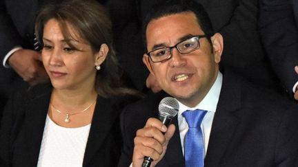 Le nouveau président du Guatemala Jimmy Morales (aux côtés de sa femme Hilda Marroquin) arbore cheveux plaqués, lunettes et cravate après son élection, le 25 octobre 2015. Un look destiné à gommer son immaturité politique. (Rodrigo ARANGUA / AFP)