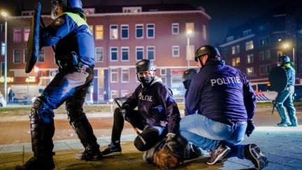 Des policiers interpellent violemment un manifestant&nbsp;à Rotterdam (Pays-Bas), le 25 janvier 2021. (MARCO DE SWART / ANP / AFP)