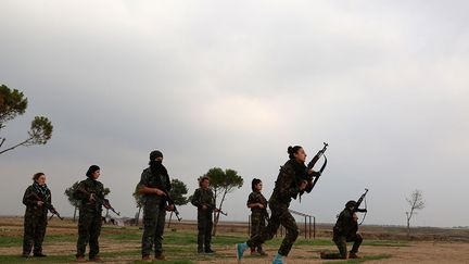 l’une des combattantes raconte qu’elle était coiffeuse. Elle a laissé de côté son rôle de mère et son métier pour rejoindre ses camarades chrétiennes. Elle explique que c'est son mari qui l'a encouragée à prendre les armes pour «lutter contre l'idée qu'une femme syriaque n'est bonne que pour les activités ménagères et le maquillage».  (AFP PHOTO / Delil Souleiman)