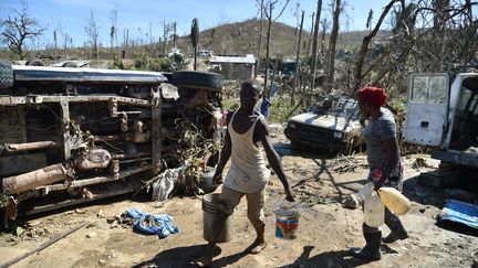 Un jeune homme porte des seaux d'eau à Jérémie, Haïti, le 9 octobre 2016. (HECTOR RETAMAL / AFP)