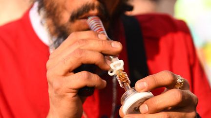 Sur cette photo d'archive prise le 20 avril 2022, une personne fume un produit concentré de cannabis, lors du Mile High 420 Festival à Denver, dans le Colorado.&nbsp; (PATRICK T. FALLON / AFP)