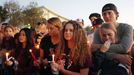 Des jeunes Floridiens assistent, à Parkland (Floride, Etats-Unis) à un hommage, le 15 février 2018, aux victimes de la tuerie perpétrée dans un lycée de la ville, qui a fait 17 morts. (RHONA WISE / AFP)